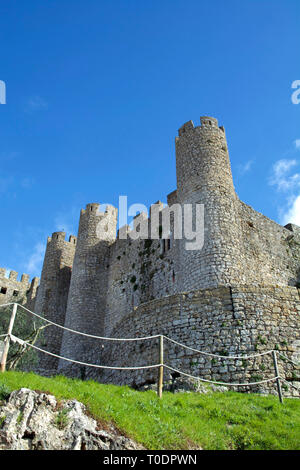 Vue partielle de l'imposant château médiéval d'Obidos dans le centre du Portugal sous un ciel bleu ensoleillé. Banque D'Images