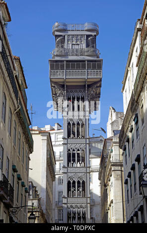 Vue frontale de la célèbre 'Elevador de Santa Justa', l'ascenseur du 19ème siècle dans le centre de transport de Lisbonne (Portugal) flanquée de maisons et en vertu d'une blu. Banque D'Images