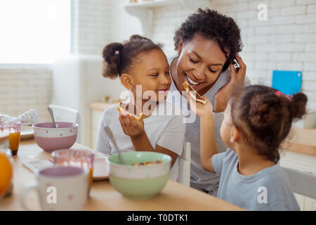 Petite fille à la peau sombre sandwich donnant à sa mère Banque D'Images