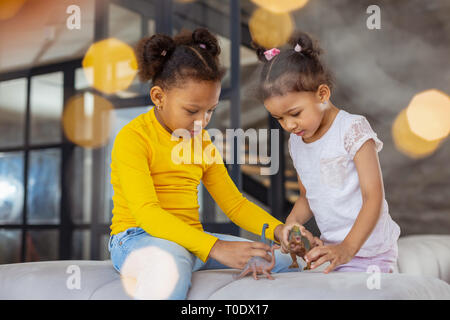 Les enfants jouent ensemble avec concentré animaux artificiels Banque D'Images