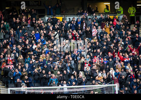 Grand groupe de fans et de supporters à un club anglais de football match célébrer leur équipe marquer un but. Banque D'Images