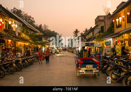 Les touristes du shopping dans les magasins ouverts la nuit en moto, et les tuk tuk, Luang Prabang, Laos, Asie Banque D'Images