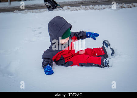 Tout-petit dans la neige répondre à profiter du premier jour de neige. Banque D'Images