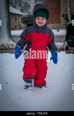 Tout-petit dans la neige répondre à profiter du premier jour de neige. Banque D'Images