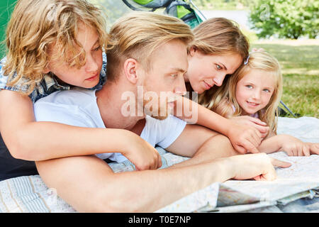 Camping en famille avec deux enfants est l'étude de la carte et la planification d'une randonnée pédestre Banque D'Images