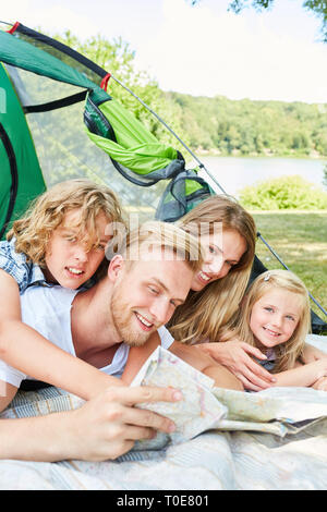 Les parents et deux enfants en tente de planifier un voyage en été locations Banque D'Images