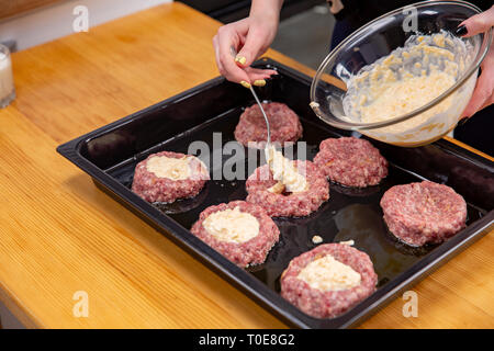 Fonds de main de femme theminced ou boulettes de viande de la farce portant sur un processus de cuisson. noir de la cuisine maison. Banque D'Images