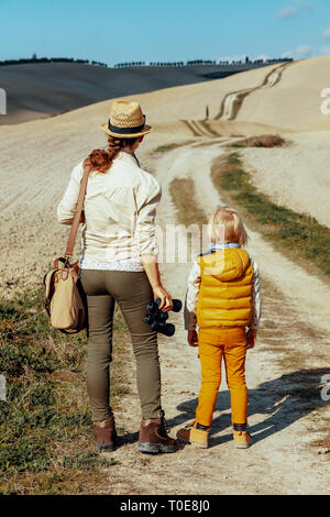 Vus de derrière, jeune mère et enfant de l'été voyage Toscane à dans la distance. Un voyage de mille kilomètres commence par un seul pas Banque D'Images
