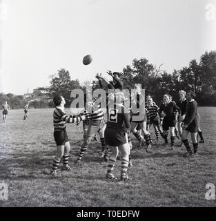 1964, match de rugby amateur, England, UK, les joueurs difficile pour la balle à une sortie ligne, où le jeu est redémarré après le ballon est allé en touche. La balle est jetée sur le terrain dans l'air et plusieurs joueurs de chaque côté saut dans l'air pour essayer de gagner la possession. Banque D'Images