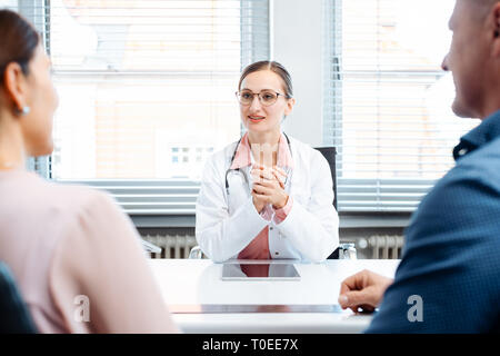 Médecin en consultation avec deux patients Banque D'Images