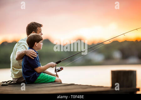 Père et fils à partir d'un quai de pêche. Banque D'Images