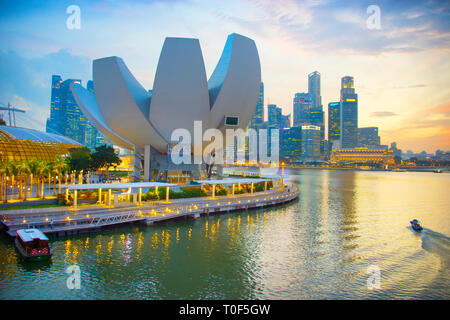 Singapour - 3 janvier 2017 : Coucher de soleil sur la baie de la marina avec l'horizon lumineux musée ArtScience lotus construction d'architecture moderne en premier plan, tr Banque D'Images