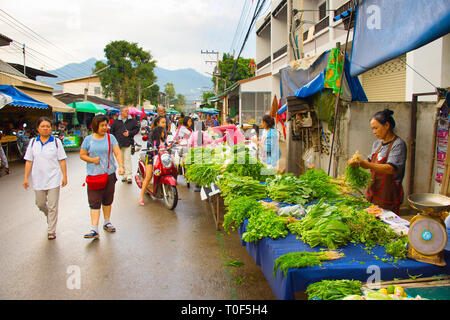 PAI, THAÏLANDE - 10 janvier 2017 : Les femmes vendant de verdure à Pai bondé de la rue du marché, montagnes en arrière-plan, la Thaïlande Banque D'Images