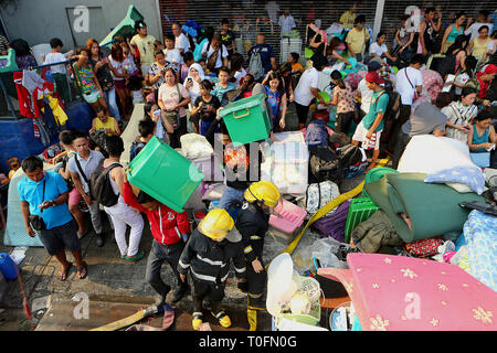 Quezon City, Philippines. Mar 20, 2019. Évacuer les résidents que leurs maisons sont la proie des flammes durant un incendie dans un bidonville à Quezon City, Philippines, le 20 mars 2019. Plus de 250 chantiers ont été rasées dans le feu, laissant 750 familles sans abri. Credit : Rouelle Umali/Xinhua/Alamy Live News Banque D'Images