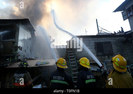 Quezon City, Philippines. Mar 20, 2019. Les pompiers tentent d'éteindre un incendie dans un bidonville à Quezon City, Philippines, le 20 mars 2019. Plus de 250 chantiers ont été rasées dans le feu, laissant 750 familles sans abri. Credit : Rouelle Umali/Xinhua/Alamy Live News Banque D'Images