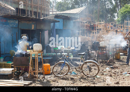 Bahir Dar, l'Éthiopie, le 14 février 2015 : scène de marché à Bahir Dar avec foyers fumeurs, un vélo à l'avant-plan et une menuiserie dans l'arrière-plan Banque D'Images