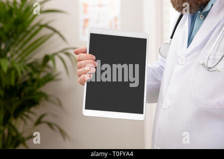 Des profils médecin homme montrant une image numérique ou d'un rapport sur une tablette Banque D'Images
