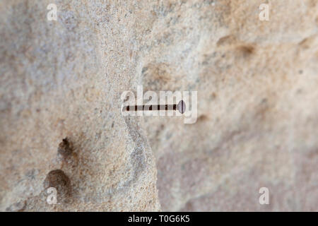 Clou sur le mur et le sable Banque D'Images