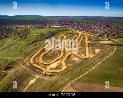 Photo aérienne de haut en bas de piste de motocross montrant la haute performance des motocyclettes hors route de course sur le circuit de terre artificiel fermé avec des jump Banque D'Images