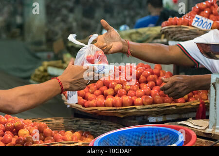 Les paiements en argent de l'acheteur après l'achat de légumes au marché de l'homme aux Maldives. Banque D'Images