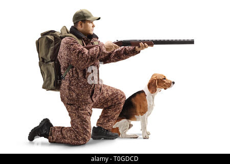 D'un coup pleine longueur genoux chasseur avec un fusil et un chien beagle isolé sur fond blanc Banque D'Images