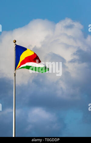 Le drapeau des Seychelles sur un ciel bleu avec des nuages. Banque D'Images