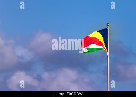 Le drapeau des Seychelles sur un ciel bleu avec des nuages. Banque D'Images