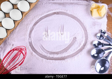 Heureux visage fait avec de la farine de cuisine sur une table en bois. Vue d'en haut. Banque D'Images