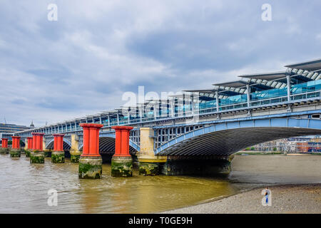 Londres, Royaume-Uni, août 2018, l'homme debout sur la rivière Thames à marée basse par le pont ferroviaire de Blackfriars, Angleterre Banque D'Images