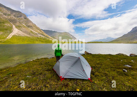 Tente gris se trouve dans une prairie dans les montagnes près du lac, dans l'orage Banque D'Images