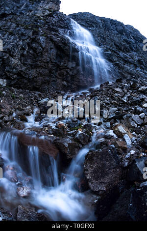 Grande Montagne cascade dans les montagnes sur les rochers humides sombre, longue exposition Paysage du soir Banque D'Images