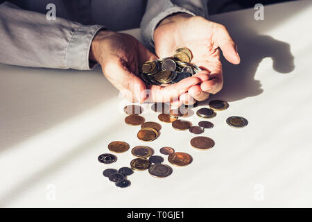 Pièces dans old woman's hands on white background with copy space Banque D'Images