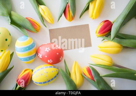 Close up d'œufs de Pâques colorés et fleurs tulipes Banque D'Images