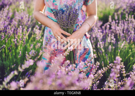 Girl Holding Bouquet sur champ de lavande Banque D'Images