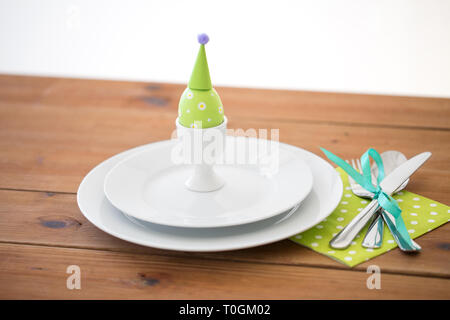 Oeuf de Pâques dans le porte-gobelet, assiettes et couverts Banque D'Images