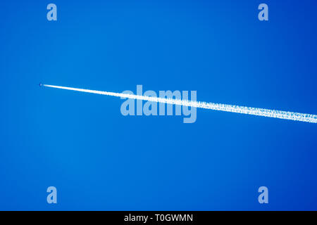 Jet Aviation commerciale dans les traînées d'un ciel bleu clair Banque D'Images
