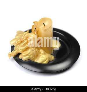 Vieille bougie de cire d'or sur un socle noir sur fond blanc isolé Banque D'Images