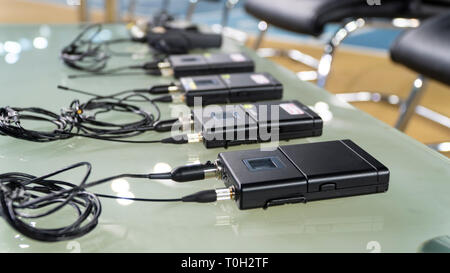 Microphone sans fil émetteur et récepteur de microphone sans fil sur une table en verre dans un studio de télévision Banque D'Images