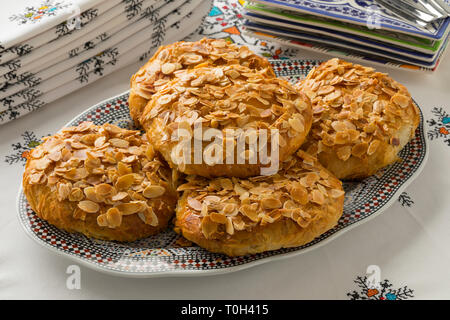 Plat avec petit bastella marocaine traditionnelle d'amandes effilées garniture sur une belle table de jeu Banque D'Images