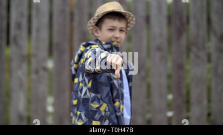 Happy boy in hat montre sa main n'aime pas, s'amuser Banque D'Images