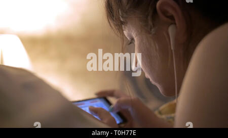 Young Beautiful woman on bed tard dans la nuit à l'aide de SMS mobile phone somnolent et fatigué à la surutilisation de communication internet concept Banque D'Images