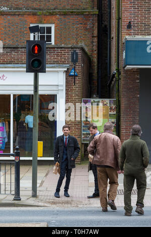 Deux hommes traversant la rue à un passage pour piétons, tandis que l'homme vert est rouge, uk Banque D'Images