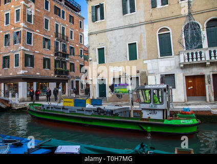 La collecte des déchets en bateau dans le canal, Venise, Vénétie, Italie Banque D'Images