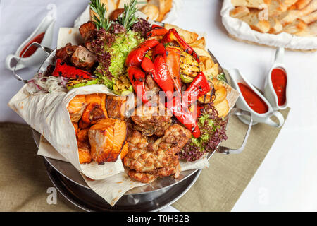 Grillade de viande, légumes et filets de poisson grillés, décoration à plat chaud. Un assortiment de délicieux kebab grillé servi avec des herbes sur plat Banque D'Images