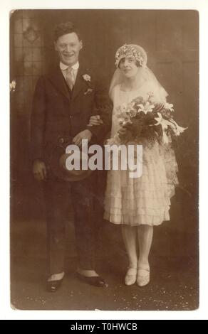 1920 Carte postale de Della et Jim's wedding - un couple très élégant. Della a le plus élevé à la mode d'ourlet.- une "flapper girl' avec coiffe et long voile. Jim s'use plus ses chaussures. spats Daté 1926 au verso, au Royaume-Uni. Banque D'Images