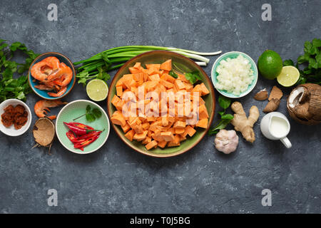 Ingrédients de base pour la cuisson de la soupe de patates douces aux crevettes sur fond sombre vue de dessus Banque D'Images