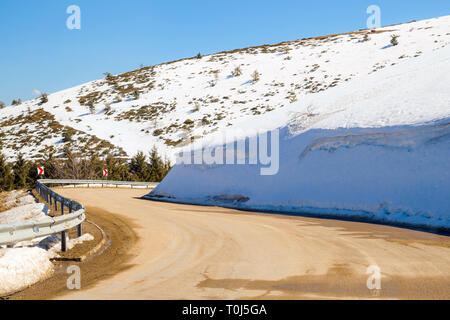 Voiture roulant sur route étroite en col Beklemeto, montagnes des Balkans, la Bulgarie. La fonte des neiges au printemps, les conditions de conduite dangereuses Banque D'Images