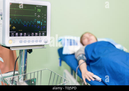 Infirmière en tenant la jeune femme asiatique la pression artérielle dans l'er prix à l'hôpital. Banque D'Images