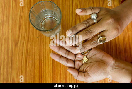 L'auto-traitement à la maison selon les prescrits par votre médecin. Close up of a woman pouring médicament dans sa main. Soins médicaux, de la santé ou de personnes concept. Un haut Banque D'Images