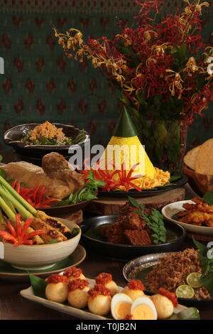 Tumpeng Nasi Nusantara. Ambiance festive et grand Rijsttafel indonésienne de riz jaune en forme de cône avec sept plats d'inspiration régionale. Banque D'Images